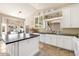 Eat-in kitchen with stone floors, white cabinets, a dark countertop island, and stainless steel appliances at 15377 W Cheery Lynn Rd, Goodyear, AZ 85395