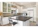 Bright kitchen featuring white cabinets, dark countertops, a center island, and stone floors at 15377 W Cheery Lynn Rd, Goodyear, AZ 85395