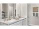 Bathroom featuring double vanity, marble countertops, modern faucets, and decorative accents at 15474 W Cottontail Ln, Surprise, AZ 85387