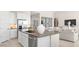 Modern kitchen showcasing stainless steel appliances, a kitchen island with sink, and an open view into the living room at 15474 W Cottontail Ln, Surprise, AZ 85387