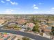 Wide aerial shot of a neighborhood featuring well-kept homes, desert landscaping, and community water features at 15563 W Roanoke Ave, Goodyear, AZ 85395