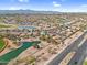 Expansive aerial view of a community with lakes, a golf course, and distant mountains at 15563 W Roanoke Ave, Goodyear, AZ 85395