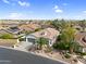 Aerial front view of a home featuring desert landscaping, a two-car garage, and a well-maintained lawn at 15563 W Roanoke Ave, Goodyear, AZ 85395