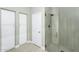 Neutral-toned bathroom featuring a glass-enclosed shower and white cabinetry at 15563 W Roanoke Ave, Goodyear, AZ 85395