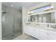 Modern bathroom showcasing a glass shower, double vanity, and bright natural light at 15563 W Roanoke Ave, Goodyear, AZ 85395