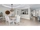 Dining room featuring white dining set, elegant lighting fixture, and a pass-through to the kitchen at 15563 W Roanoke Ave, Goodyear, AZ 85395