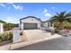 Front exterior of a house with a two-car garage, desert landscaping, and a well-maintained driveway at 15563 W Roanoke Ave, Goodyear, AZ 85395