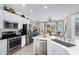 Well-lit kitchen features stainless steel appliances, white cabinets, and breakfast nook at 15563 W Roanoke Ave, Goodyear, AZ 85395