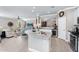 Open-concept kitchen with island seating, flowing into the living room and dining area at 15563 W Roanoke Ave, Goodyear, AZ 85395