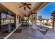 Stylish covered patio offers a comfortable seating area with a ceiling fan and a view of the refreshing pool at 16438 W Mescal St, Surprise, AZ 85388