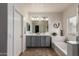 Well-lit main bathroom with double vanity, bathtub, and decorative accents at 16438 W Mescal St, Surprise, AZ 85388