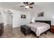 Bright main bedroom with a ceiling fan, bench, and tile flooring at 16438 W Mescal St, Surprise, AZ 85388