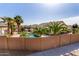 An elevated view of a backyard pool surrounded by tall palm trees and desert landscaping at 16438 W Mescal St, Surprise, AZ 85388