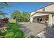 Beautiful backyard featuring a covered patio, lush green grass, mature trees and a seating area perfect for relaxation at 16881 W Monroe St, Goodyear, AZ 85338