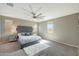 Spacious bedroom featuring a tufted headboard, plush rug, and a modern ceiling fan at 16881 W Monroe St, Goodyear, AZ 85338