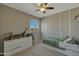 bedroom featuring a themed accent wall, neutral carpet and modern ceiling fan at 16881 W Monroe St, Goodyear, AZ 85338