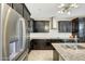 Modern kitchen featuring granite countertops, sleek black cabinets, and stainless steel appliances at 16881 W Monroe St, Goodyear, AZ 85338