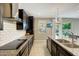 Modern kitchen featuring granite countertops, sleek black cabinets, and stainless steel appliances at 16881 W Monroe St, Goodyear, AZ 85338