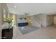 Bright living room featuring tile floors, a plush blue sofa, and staircase to the second level at 16881 W Monroe St, Goodyear, AZ 85338