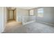 Carpeted loft area with staircase, a bright window, and neutral walls, offering a versatile space at 16881 W Monroe St, Goodyear, AZ 85338