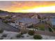 Gorgeous sunset view of the backyard with a sparkling pool, outdoor kitchen, and lush landscaping at 19051 N 259Th Ave, Buckeye, AZ 85396