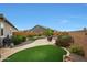 Backyard showcasing a well-manicured lawn with stone pathways and lush landscaping at 19051 N 259Th Ave, Buckeye, AZ 85396