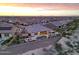 Aerial view of a home and a backyard featuring a pool and manicured landscaping at sunset at 19051 N 259Th Ave, Buckeye, AZ 85396