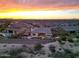 A scenic aerial shot showcasing the home's backyard oasis and the surrounding neighborhood at sunset at 19051 N 259Th Ave, Buckeye, AZ 85396