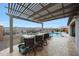 Covered outdoor kitchen featuring a built-in grill and bar seating, plus backyard pool and mountain views at 19051 N 259Th Ave, Buckeye, AZ 85396