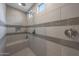 Modern shower with two shower heads, gray tile, built in seating, and window at 19051 N 259Th Ave, Buckeye, AZ 85396