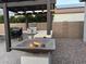 Outdoor kitchen area with built-in grill, pergola, and a cozy fire pit in the backyard at 19736 E Emperor Blvd, Queen Creek, AZ 85142