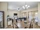 Open-concept living and dining area features wood-look tile floors, chandelier and ample seating at 19736 E Emperor Blvd, Queen Creek, AZ 85142