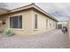 Exterior showcases clean architecture with windows and gravel landscaping; an invitation to explore what's inside at 203 S La Amador Trl, Casa Grande, AZ 85194