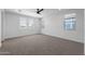 Bright bedroom featuring neutral carpet, ceiling fan, and multiple windows at 20979 E Mayberry Rd, Queen Creek, AZ 85142