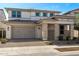 Inviting two-story home featuring a large two-car garage and a stylish stone-accented entrance at 20979 E Mayberry Rd, Queen Creek, AZ 85142