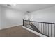 Upper level hallway with carpeted floors, black metal stair rail and bright natural lighting at 20979 E Mayberry Rd, Queen Creek, AZ 85142