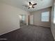 This bedroom features neutral walls and carpet, a ceiling fan, window, and a sliding door closet at 2146 E Aloe Pl, Chandler, AZ 85286