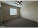 Carpeted bedroom with ceiling fan, neutral walls and a window providing natural light at 2146 E Aloe Pl, Chandler, AZ 85286