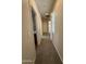 Hallway with neutral walls, carpet, and a window allowing natural light to flow through the space at 2146 E Aloe Pl, Chandler, AZ 85286