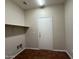 A simple laundry room is equipped with essential hookups, shelf, and door for privacy at 2146 E Aloe Pl, Chandler, AZ 85286