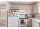 Kitchen featuring stainless steel appliances, white cabinets, and a large refrigerator at 2177 S Weaver Dr, Apache Junction, AZ 85120