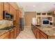 Kitchen island with stainless appliances, stone countertops and view to adjacent living area at 22139 N 80Th Ln, Peoria, AZ 85383