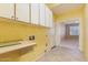 Laundry room featuring white cabinets, neutral tile, and open doorway at 22139 N 80Th Ln, Peoria, AZ 85383