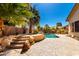 Lush backyard with rock water feature and sparkling pool providing a serene outdoor escape at 22139 N 80Th Ln, Peoria, AZ 85383