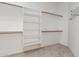 Spacious walk-in closet featuring wood rods and shelving, perfect for organizing clothes and accessories at 22139 N 80Th Ln, Peoria, AZ 85383