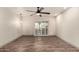 Bright bedroom featuring wood-look floors, a ceiling fan, and sliding glass door at 2415 Leisure World --, Mesa, AZ 85206