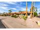 Single story tan home featuring desert landscaping, red gravel, palm trees, and a red tile roof at 2415 Leisure World --, Mesa, AZ 85206