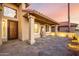 Stunning outdoor patio area featuring stone pavers, water feature, desert landscaping, and lighting at 2415 Leisure World --, Mesa, AZ 85206