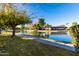 Picturesque view of the pond with a walking path and residences in the background at 2415 Leisure World --, Mesa, AZ 85206