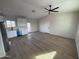 Bright living room with wood-look floors, ceiling fan, and an adjacent kitchen with new appliances at 24184 E King Rd, Florence, AZ 85132